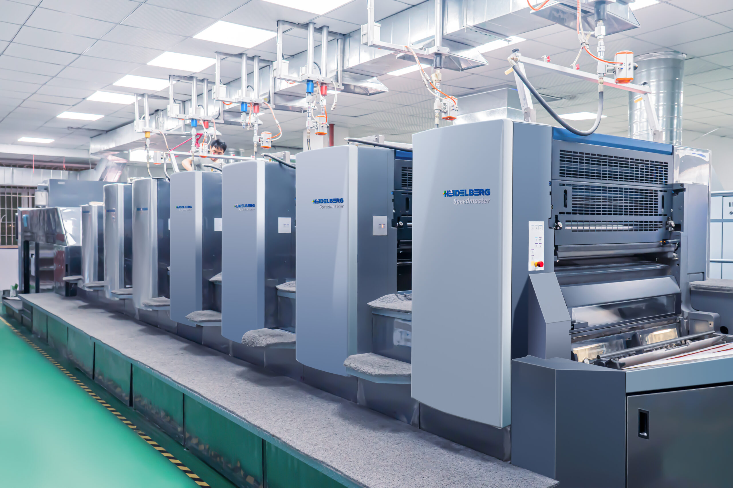 Heidelberg Speedmaster offset press with several printing units inside a card printing workshop