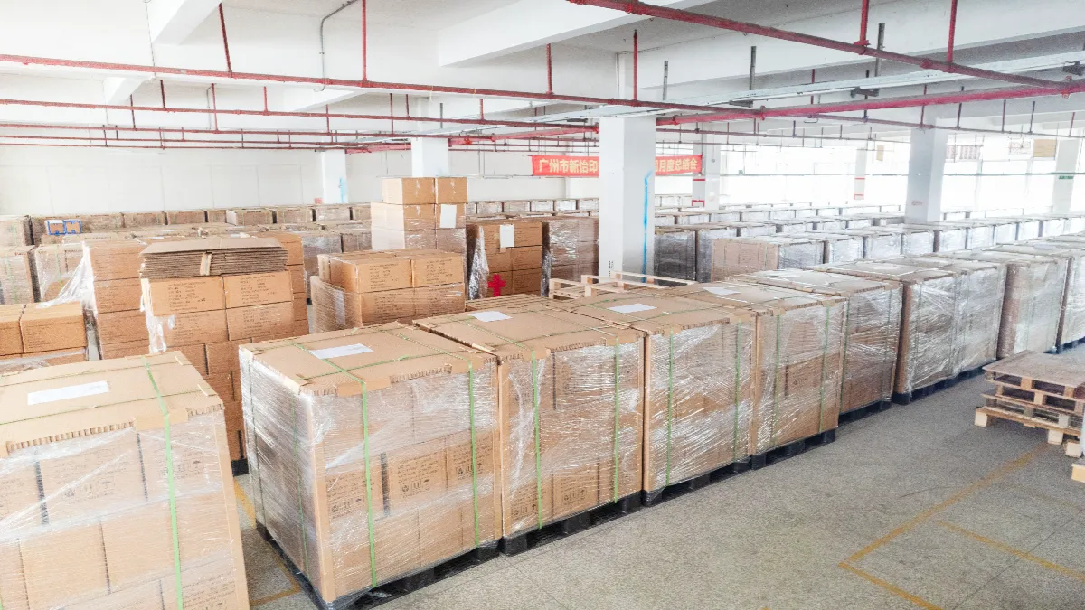 Warehouse floor holding shrink-wrapped pallets of brown export cartons