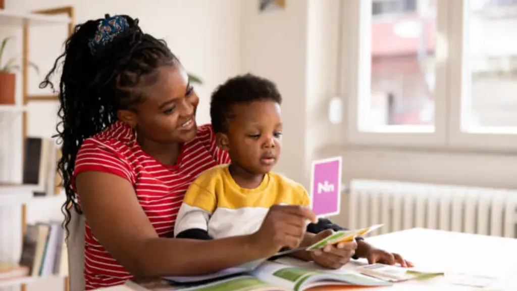 mother teaching alphabet to her baby with flashcards