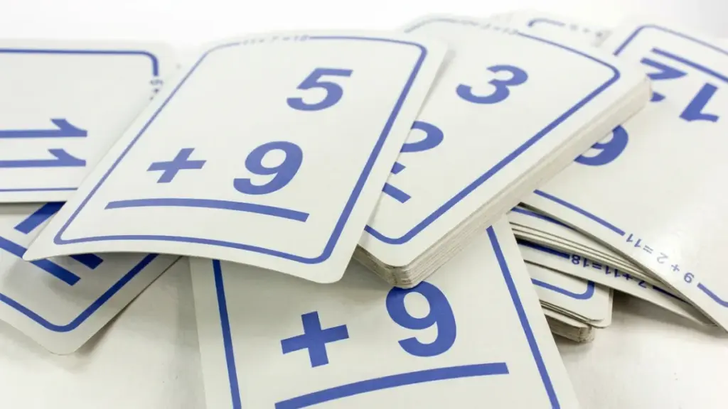 Stacked blue-and-white addition flashcards on a table