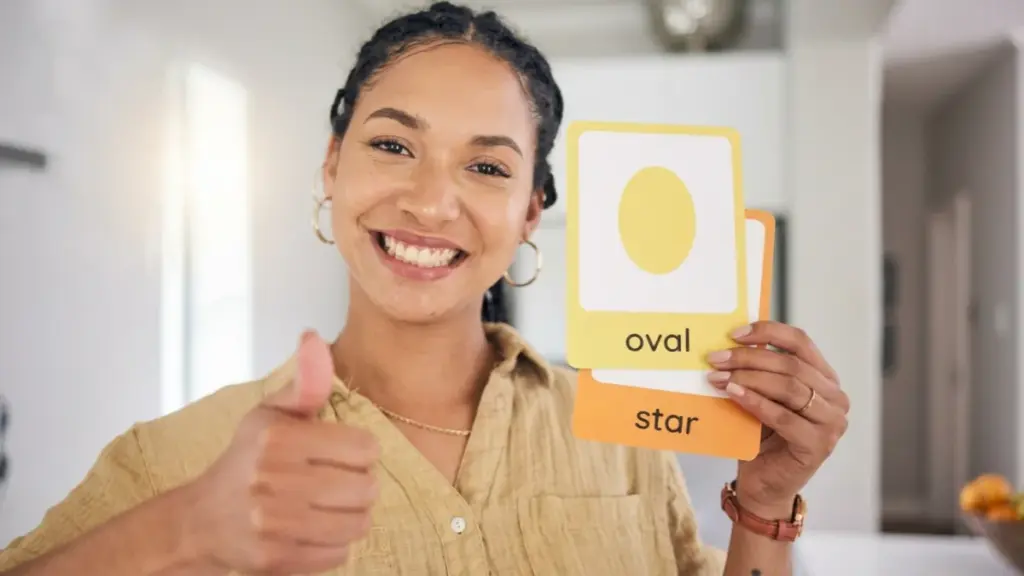 Woman holding shape flashcards and giving thumbs up