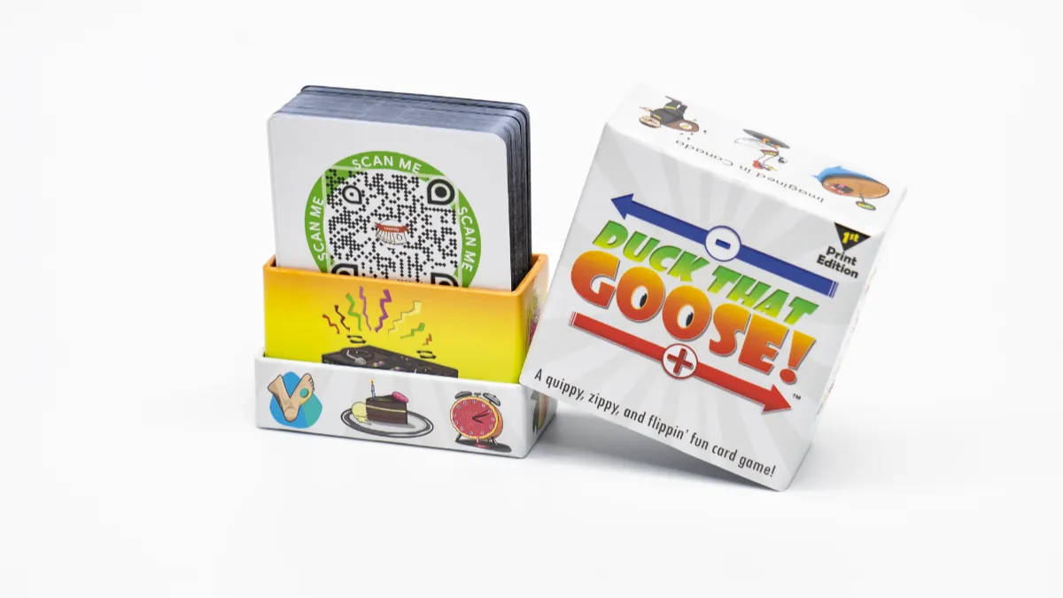 Open two-piece rigid card box with a deck inside and its printed lid leaning against the base