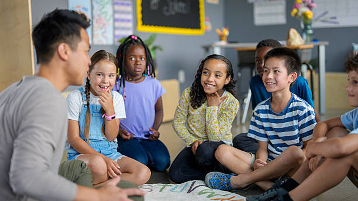 Teacher leading a group activity with young students seated in a classroom