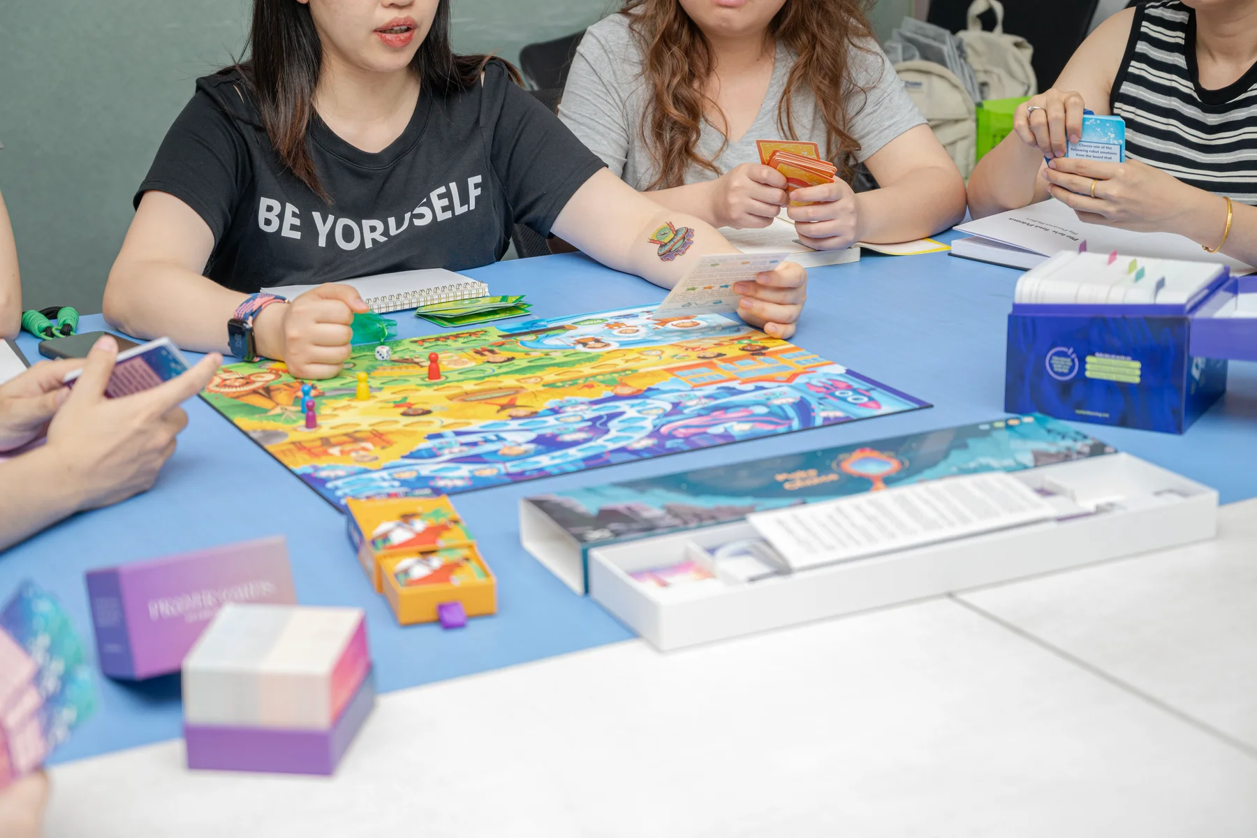People playing a tabletop card game with printed cards